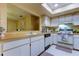 Kitchen boasts ample counter space, white cabinets, and a pass-through to dining area at 3283 Hilary Cir # 2C, Palm Harbor, FL 34684