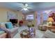 Spacious living room with kitchen peek, seating area, and ceiling fan at 3283 Hilary Cir # 2C, Palm Harbor, FL 34684