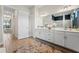 Bright bathroom with dual sinks, elegant decor, and hallway access at 10385 Sunday Dr, Port Charlotte, FL 33981