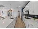 Contemporary kitchen features white cabinets, a long island with a sink, and a view into other rooms at 10385 Sunday Dr, Port Charlotte, FL 33981