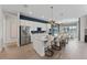 Modern kitchen features a large island with seating, stainless steel appliances, and stylish pendant lighting at 10385 Sunday Dr, Port Charlotte, FL 33981
