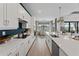 Well-lit kitchen with white cabinetry, stainless steel appliances, and views of the dining area and outdoor scenery at 10385 Sunday Dr, Port Charlotte, FL 33981
