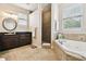 Spa-like bathroom with soaking tub, walk-in shower, and double vanity at 3104 W Fielder St, Tampa, FL 33611