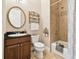 Clean bathroom with dark brown vanity, tile shower/tub combo, and decorative accents at 3104 W Fielder St, Tampa, FL 33611