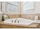 Relaxing corner bathtub with tile surround and window at 3104 W Fielder St, Tampa, FL 33611