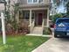 Charming front porch with red door and manicured lawn, featuring tropical plants and a welcoming entryway at 3104 W Fielder St, Tampa, FL 33611