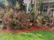 Lush tropical landscaping featuring colorful plants and mulch in front of a charming home at 3104 W Fielder St, Tampa, FL 33611