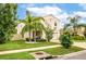 Two story house with beige exterior, two car garage, and palm trees at 409 Serenity Mill Loop, Ruskin, FL 33570