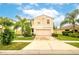 Two story house with beige exterior, two car garage, and palm trees at 409 Serenity Mill Loop, Ruskin, FL 33570