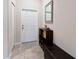 Bright entryway with white door, mirror, and storage bench at 10005 Caraway Spice Ave, Riverview, FL 33578