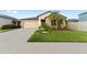 Tan house with a two-car garage and lush landscaping at 10005 Caraway Spice Ave, Riverview, FL 33578