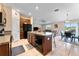 Open kitchen with island, dark wood cabinets, and stainless steel appliances at 10005 Caraway Spice Ave, Riverview, FL 33578