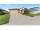 Tan house with a two-car garage and well-manicured lawn at 10005 Caraway Spice Ave, Riverview, FL 33578