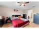 Bedroom with a red comforter, ceiling fan, and ample closet space at 10005 Caraway Spice Ave, Riverview, FL 33578