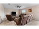 Spacious living room featuring brown leather reclining furniture and a ceiling fan at 10005 Caraway Spice Ave, Riverview, FL 33578