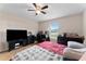 Bedroom with red bedding, ceiling fan, and a view of the backyard at 10005 Caraway Spice Ave, Riverview, FL 33578