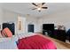 Bedroom with red bedding, ceiling fan, and a view of the bathroom at 10005 Caraway Spice Ave, Riverview, FL 33578