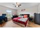 Bedroom with red bedding, ceiling fan, and a home office area at 10005 Caraway Spice Ave, Riverview, FL 33578
