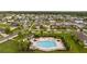 Aerial view of community pool with surrounding lush landscaping and patio furniture at 10005 Caraway Spice Ave, Riverview, FL 33578