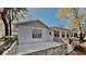 The backyard has a concrete patio with a retaining wall accented with stone and mature trees surrounding the home at 2607 Royal Ridge Dr, Spring Hill, FL 34606