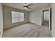 Bright bedroom with a ceiling fan, large window, neutral carpet, and a double-door closet at 2607 Royal Ridge Dr, Spring Hill, FL 34606
