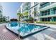 Outdoor pool area with palm trees, lounge chairs, and a modern condo building backdrop at 912 Channelside Dr # 2316, Tampa, FL 33602