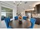 Elegant dining room with a round table and modern chandelier, adjacent to kitchen at 15449 Santa Pola Dr, Wimauma, FL 33598