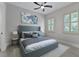 Spacious bedroom with gray upholstered bed and window seating at 638 Limona Woods Dr, Brandon, FL 33510