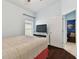 Bright bedroom with hardwood floors, a TV, and a glimpse into an adjacent, uniquely decorated room at 6843 Boulder Run Loop, Wesley Chapel, FL 33545