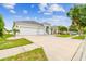 Charming single-story home with a well-manicured lawn, palm trees, a three-car garage, and an inviting entryway at 6843 Boulder Run Loop, Wesley Chapel, FL 33545