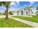 Beautiful home showcasing a well-manicured lawn, mature trees, and colorful front door, creating a welcoming ambiance at 6843 Boulder Run Loop, Wesley Chapel, FL 33545