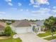 Beautiful home with a well-manicured lawn, mature trees, colorful door, and a spacious driveway, showcasing charm and appeal at 6843 Boulder Run Loop, Wesley Chapel, FL 33545