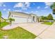 An inviting home with a spacious three-car garage, well-maintained lawn and landscaping, and a stately entrance at 6843 Boulder Run Loop, Wesley Chapel, FL 33545