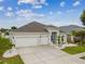 Attractive home with a large driveway, three-car garage, palm trees, and well-maintained landscaping, offering curb appeal at 6843 Boulder Run Loop, Wesley Chapel, FL 33545