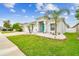 Inviting single-story home featuring a three-car garage and a nicely landscaped front yard with palm trees at 6843 Boulder Run Loop, Wesley Chapel, FL 33545