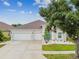 Inviting home with vibrant blue door, manicured lawn, and spacious two-car garage at 6843 Boulder Run Loop, Wesley Chapel, FL 33545