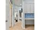 Hallway with view of bathroom and kitchen, tile flooring, and blue accent wall at 6843 Boulder Run Loop, Wesley Chapel, FL 33545