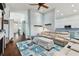 Inviting living room with a large couch, coastal-themed rug, and open access to the kitchen at 6843 Boulder Run Loop, Wesley Chapel, FL 33545