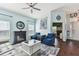 Cozy living room featuring a fireplace, blue accent chairs, and elegant decor with nautical themed decor at 6843 Boulder Run Loop, Wesley Chapel, FL 33545