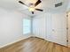 Bedroom with ceiling fan, wood-look floors, and double door closet at 13336 Great Plains Dr, Riverview, FL 33579