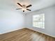 Bright bedroom with hardwood floors, a ceiling fan, and a large window at 13336 Great Plains Dr, Riverview, FL 33579