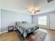 Bedroom with wood-look floors, ceiling fan and window with backyard view at 13336 Great Plains Dr, Riverview, FL 33579