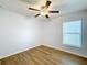 Bright bedroom with ceiling fan, wood-look floors, and large window at 13336 Great Plains Dr, Riverview, FL 33579