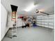 Garage with attic access, storage shelving, and epoxy flooring at 13336 Great Plains Dr, Riverview, FL 33579