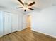 Bedroom with ceiling fan, wood-look floors, and door to hallway at 13336 Great Plains Dr, Riverview, FL 33579