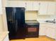 Kitchen with black appliances and white cabinets at 1655 S Highland Ave # F133, Clearwater, FL 33756