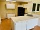 Kitchen with white cabinets, black appliances, and a breakfast bar at 1655 S Highland Ave # F133, Clearwater, FL 33756