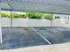 Covered guest parking area with designated spaces and white fencing at 1655 S Highland Ave # F133, Clearwater, FL 33756