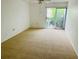 Spacious bedroom with carpet, ceiling fan, and sliding glass doors to patio at 1655 S Highland Ave # F133, Clearwater, FL 33756