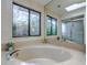 Bathroom with an oversized soaking tub under a large garden window and a large mirror at 35070 Smoketree Ln, Dade City, FL 33523